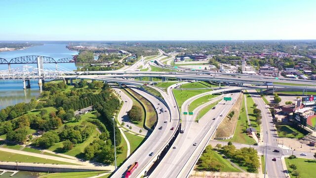 Aerial over freeway interchange in Louisville, Kentucky with Ohio River background suggests infrastructure.