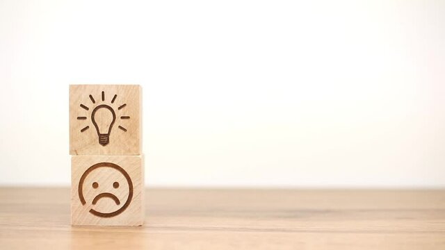 Business strategy and new creative idea concept. Hand arranging wooden block with light bulb and smiley face icon