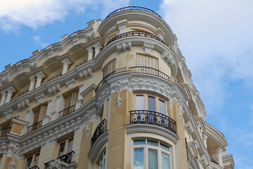 Corner of beige classical building on Gran Via street in Madrid, Spain