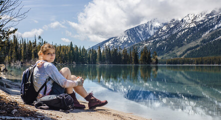 Fototapeta na wymiar woman sitting next to a mountainous lake