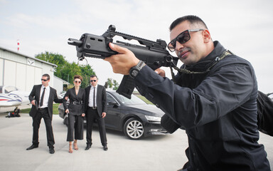 Agent bodyguard with machinegun protect celebrity VIP person. Security protection