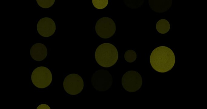 Abstract background of glowing shiny moving blurry bokeh particles, sparkles on black background. Blurred defocused Christmas pattern with sparkles.