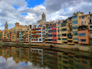 Naklejka premium Colorful historical houses,facades, reflected in water of the river Onyar, in Girona, Catalonia, Spain. 