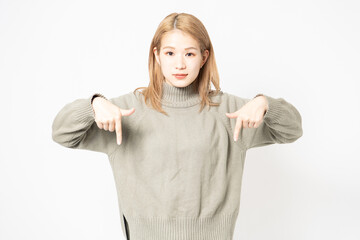 指でポイントを示すセーターを着た若い女性