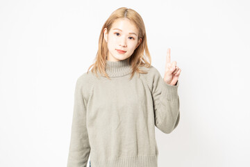 指でポイントを示すセーターを着た若い女性