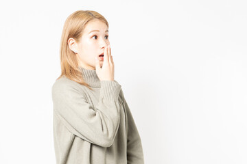 驚いたポーズをするセーターを着た若い女性