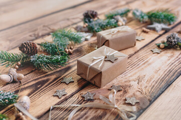 gifts, spruce branches, cones and stars lying on a wooden tabletop
