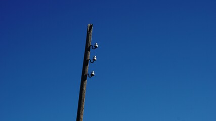 wireless electricity pole against sky background