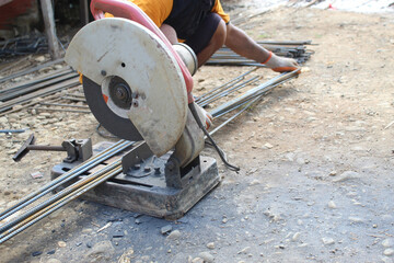 worker cutting metal with saw