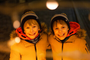 dwóch chłopców bliźniaki zima światła święta