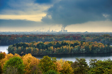 autumn landscape with lake in front of industrial backdrop