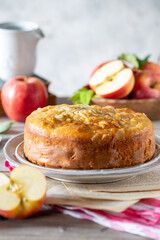 Torta di mele in primo piano e varie mele sullo sfondo 