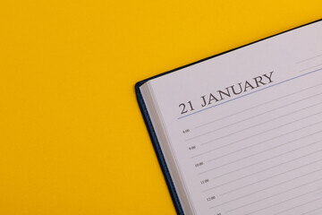 Notepad or diary with the exact date on a yellow background. Calendar for January 21 - winter time. Space for text.