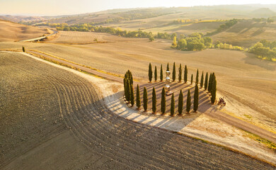 Aerial view of the beautiful hills of the Val d'Orcia in Tuscany with the cypress circle shape...