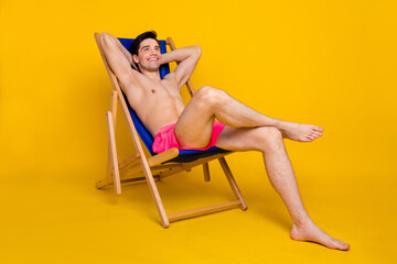 Full length photo of nice young guy sit dream wear pink shorts isolated on yellow background