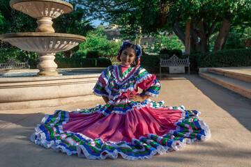 Naklejka premium BAILARINA TRADICIONAL MEXICANA SENTADA EN FUENTE DE AGUA