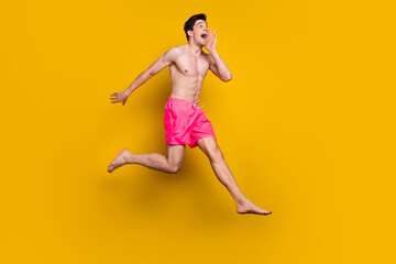 Fototapeta na wymiar Full size profile side photo of young man happy positive smile run jumper speak tell news isolated over yellow color background
