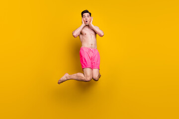 Fototapeta na wymiar Full length photo of young man amazed shocked fake novelty news jumper swimwear isolated over yellow color background