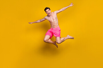 Fototapeta na wymiar Full length body size view of attractive cheerful funny guy jumping diving having fun isolated over shine yellow color background