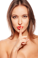 young woman showing quiet sign with finger on her lips