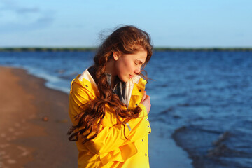 Thoughtful Portrait of a Young Female Model With Curly Hair on the Riverside Beach