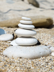 Fototapeta na wymiar White pebble stack on a sandy beach