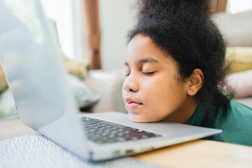 Lazy African American girl with the computer before studying online at home.