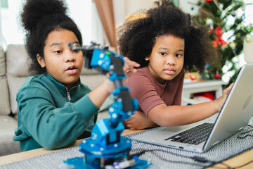 Two African American girls learned robot arms with a program computer. Innovative technology mechanical for Assistive Technology