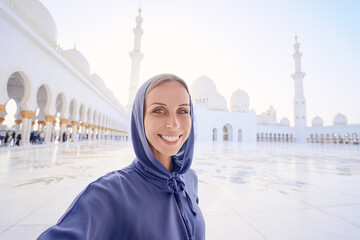 Traveling by Unated Arabic Emirates. Pretty young woman in traditional abaya taking selfie in the...