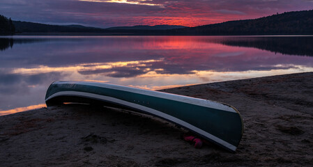 morning sunrise with canoe on shoreline of lake of Two Rivers Algonquin Park