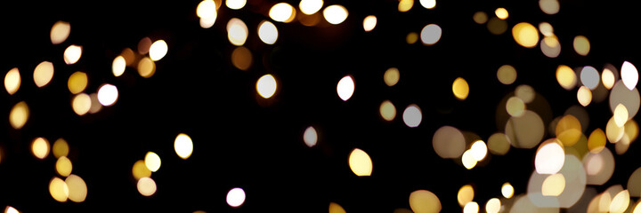 Banner made with gold light blurred. Abstract boken texture. Festive background. Glitter light spots on black background.