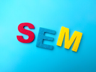 Colored word with text SEM on a blue background.