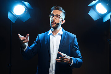 Motivational speaker with headset performing on stage - Powered by Adobe