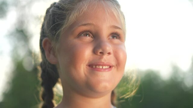 portrait of a little girl in nature smiling in the park. happy family kid dream concept. daughter with chubby cheeks cheerful smiling in the park. little girl close-up. family childhood happy concept