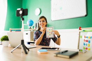Beautiful teacher filming an online class