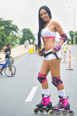 Latina woman skating in the street. With protection on elbows and knees