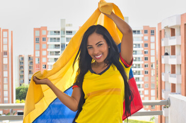 Fototapeta premium Cheerful woman with Colombian flag. Colombian soccer, Colombia national team