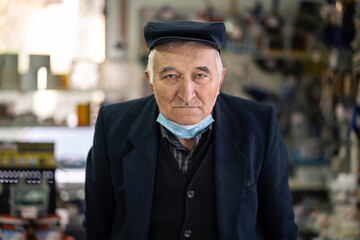 One senior man pensioner old male portrait front view standing looking to the camera indoor wearing...