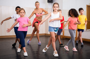 Group of children training in class, learning dance movements