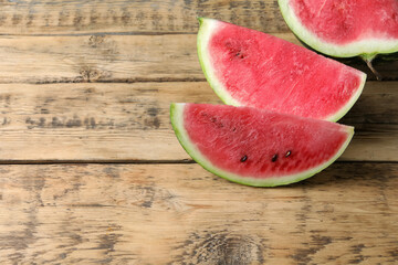 Delicious fresh watermelon slices on wooden table. Space for text