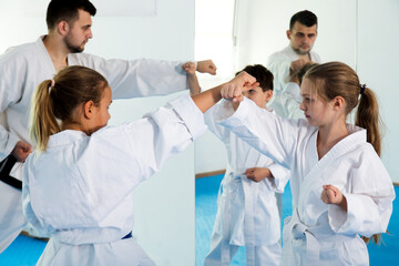 Obraz premium Happy children enjoying their trainings with coach at karate classes