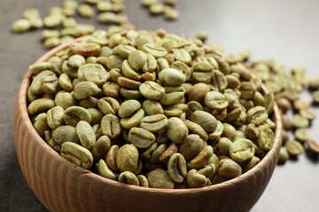 Green coffee beans on grey table, closeup