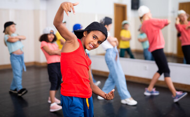 Portrait of preteen Afro-American boy performing hip hop at group dance class