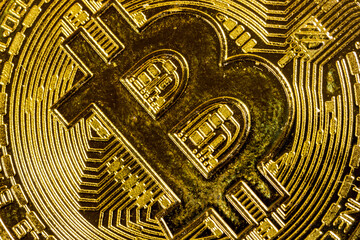 Close-up of gold Bitcoin coins on wooden background.
