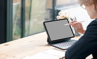man hand using digital pen writing on portable tablet screen.
