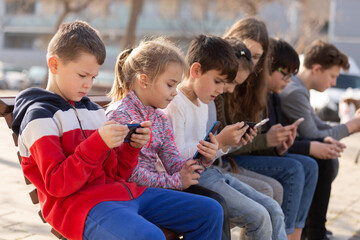 Children are playing on smartphone in the playground. High quality photo