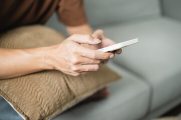 Obraz na płótnie Canvas Relaxed young asian man using smart phone spending time checking news social media