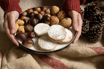Unrecognizable woman offering a tray with polvorones