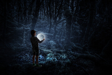 Boy holding moon at night