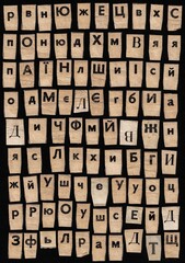 Set of letters of the Ukrainian and Russian alphabet on pieces of cut bent vintage paper isolated on black background for school